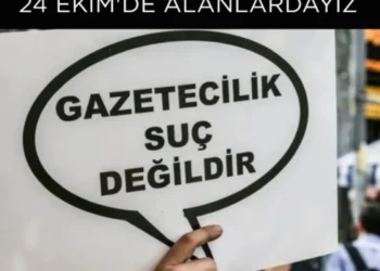 Gazetecilik suç değildir" yazılı bir döviz tutan el.