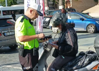 Trafik polisinin bir motosiklet sürücüsünü durdurup kontrol etmesi.