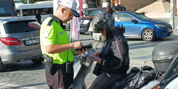 Trafik polisinin bir motosiklet sürücüsünü durdurup kontrol etmesi.