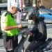 Trafik polisinin bir motosiklet sürücüsünü durdurup kontrol etmesi.