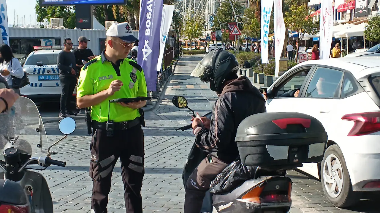 Motosiklet sürücüsünü denetleyen bir Türk trafik polisi.