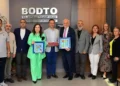 Bodrum Ticaret Odası'nda bir grup insan plaketlerle poz veriyor.