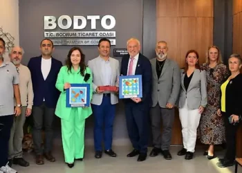 Bodrum Ticaret Odası'nda bir grup insan plaketlerle poz veriyor.