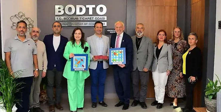 Bodrum Ticaret Odası'nda bir grup insan plaketlerle poz veriyor.
