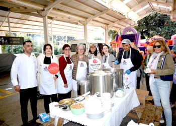Slow Food Bodrum etkinliğinde yemek dağıtan gülümseyen grup.