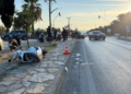 Yol kenarında kaza yapmış, yan yatmış beyaz bir motosiklet.