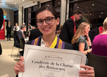 Chaîne des Rôtisseurs sertifikasını tutan gülümseyen kadın sommelier.