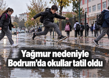 Yağmurlu bir günde su birikintisi üzerinden atlayan okul çocukları.
