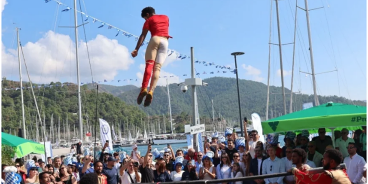 Limanda kalabalığın önünde havaya zıplayan akrobatik gösterici.