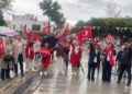 Türk bayrakları sallayan coşkulu bir grup insan.