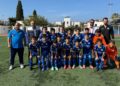 Sahada toplu fotoğraf çektiren mavi formalı çocuk futbol takımı.