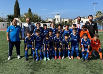 Sahada toplu fotoğraf çektiren mavi formalı çocuk futbol takımı.
