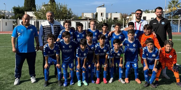 Sahada toplu fotoğraf çektiren mavi formalı çocuk futbol takımı.