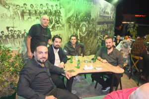 Duvar resmi önünde masada oturan bir grup adam.