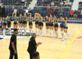Voleybol sahasında kutlama yapan kadın sporcular ve teknik ekip.