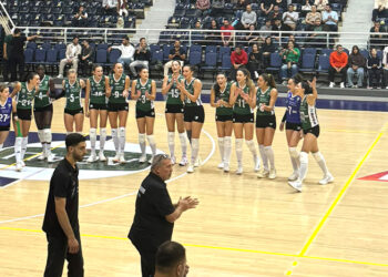 Voleybol sahasında kutlama yapan kadın sporcular ve teknik ekip.