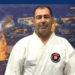 Beyaz karate kıyafeti giymiş orta yaşlı bir adamın portresi.